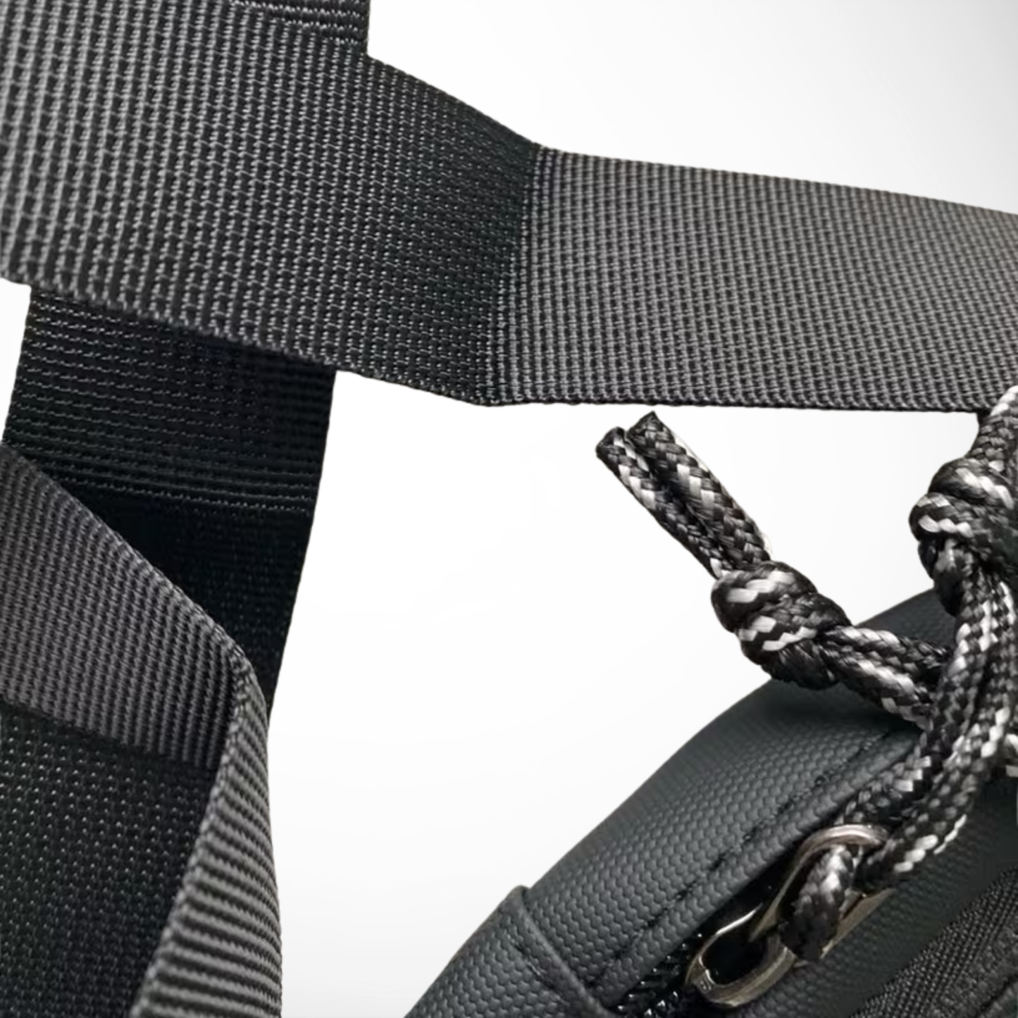 Close-up of a black strap with a metal buckle and rope on a white background