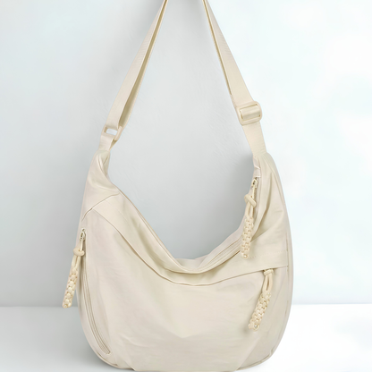 Beige handbag with a strap on a light gray background