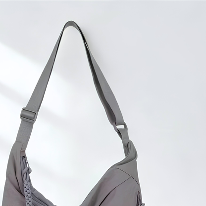 Gray shoulder bag with a strap on a light gray background