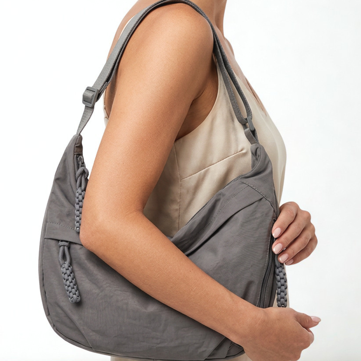Gray shoulder bag held by a person on a white background