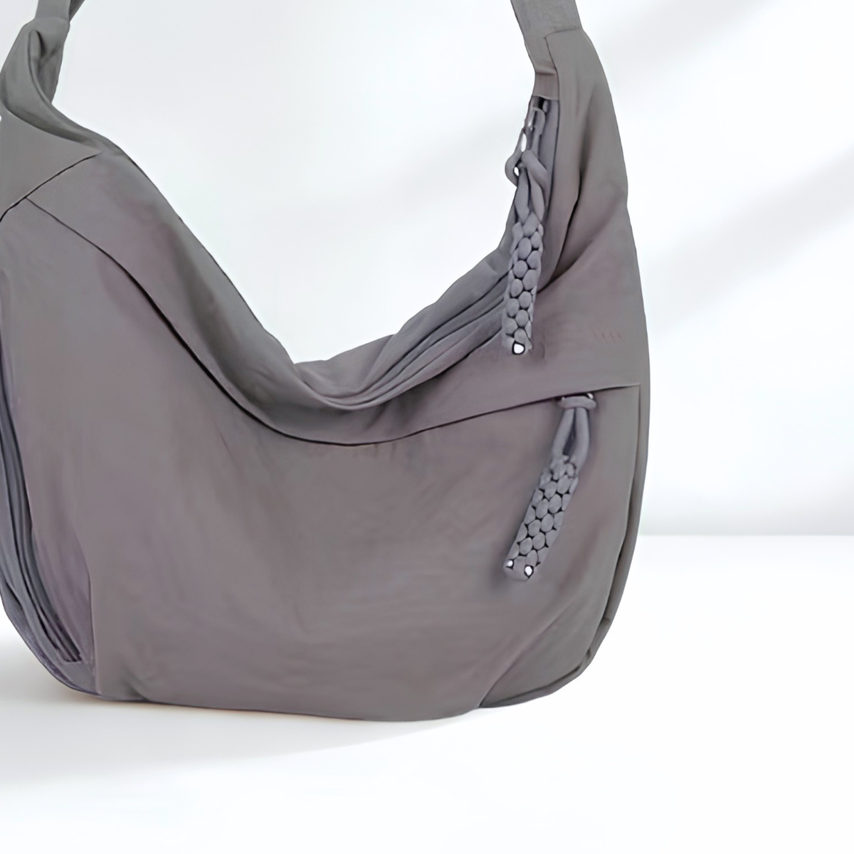 Gray shoulder bag with a zipper on a white background