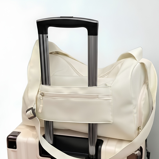 Cream duffel back with luggage bag flap sitting on luggage bag